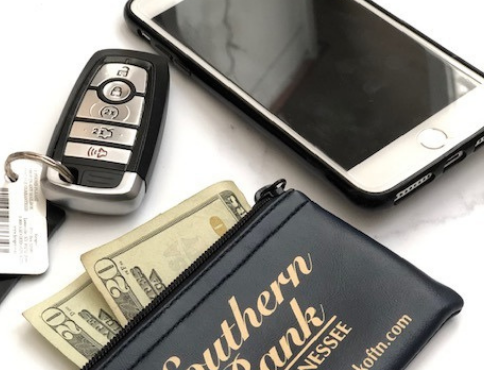 Iphone, wallet with money and car keys on a table