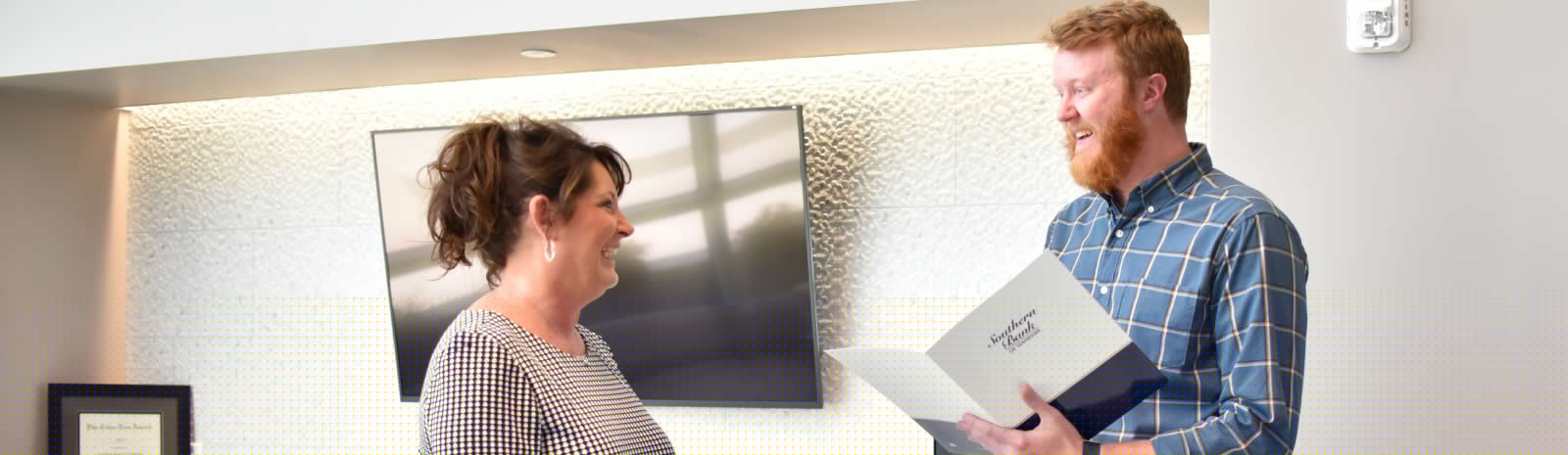 two employees engaging in a smile