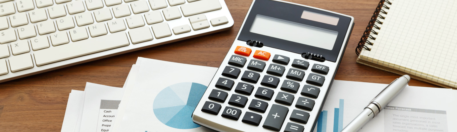 a calculator, writing pen, desktop keyboard and documents on a desk